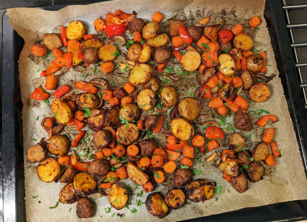 Tray with baked potatoes, carrots and bell peppers